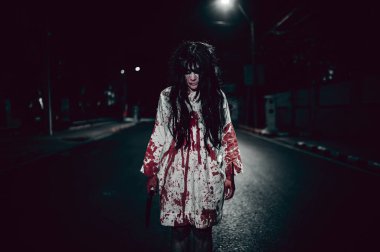 Korkunç kadın konsepti. Şehirdeki yolda bir hayalet var. Şehrin sokaklarında intikamcı bir ruh. Cadılar Bayramı festivali. Makyaj yapan hayalet surat