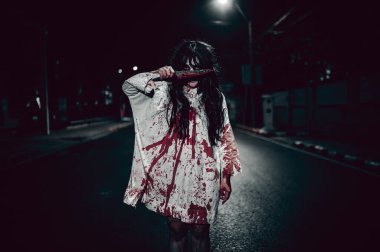 Korkunç kadın konsepti. Şehirdeki yolda bir hayalet var. Şehrin sokaklarında intikamcı bir ruh. Cadılar Bayramı festivali. Makyaj yapan hayalet surat