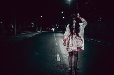 Korkunç kadın konsepti. Şehirdeki yolda bir hayalet var. Şehrin sokaklarında intikamcı bir ruh. Cadılar Bayramı festivali. Makyaj yapan hayalet surat