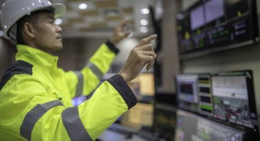 Kontrol odasında çalışan bir mühendis. Yönetici kontrol sistemi. Birçok monitörden teknisyen izleme programı