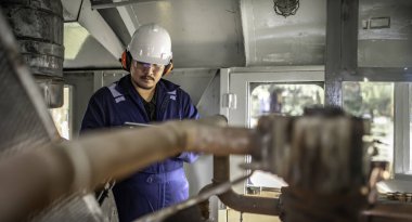 Makine mühendisi fabrikadaki büyük makineleri inceliyor. Demiryolu motor bakım teknisyeni, motor tamircisi.