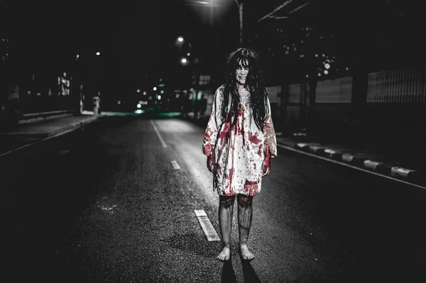 Horror woman concept. Ghost on the road in the city. A vengeful spirit on the street of the town. Halloween festival. Make up ghost face