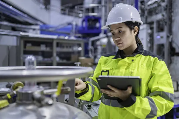 Ameliyathanede çalışan Asyalı mühendis. Taylandlılar kask takar. Adam özenle ve sabırla çalışmış, kadın hidrojen tankındaki valf düzenleyicisini kontrol etmiş..