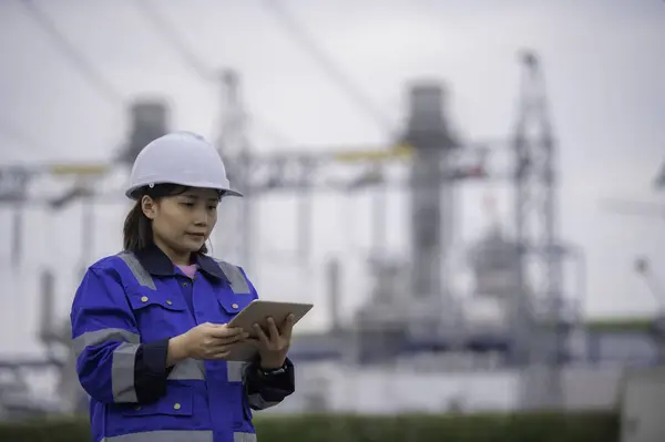 Asian woman petrochemical engineer working at oil and gas refinery plant industry factory. The worker woman engineer work control at power plant energy industry manufacturing