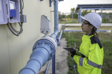 Çevre mühendisleri atık su arıtma tesislerinde çalışıyor. Su ikmali yapan kadın tesisatçı teknisyen.