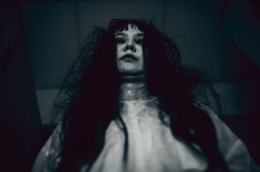 Hayaletten yapılmış Asyalı kadın portresi. Arka plan için korkunç bir korku sahnesi. Cadılar Bayramı festivali kavramı. Hayalet filmleri afişi, evde öfkeli bir ruh.