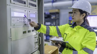 Elektrik mühendisi kadın kontrol odasındaki elektrik dağıtım kabinesindeki voltajı kontrol ediyor. Yıllık önleyici bakım. Tayland Elektrikçisi şirkette çalışıyor.