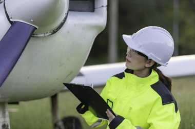 Teknisyen uçağın motorunu tamir ediyor. Kadın uzay mühendisliği uçak motorlarını kontrol ediyor. Asyalı tamirci uçak motorunu inceliyor