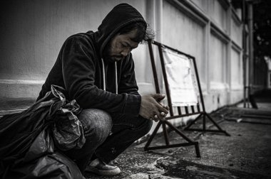 Asyalı adam yan yolda evsiz. Bir yabancı, ailesi olmadığı için yolda tek başına yaşamak zorundadır..