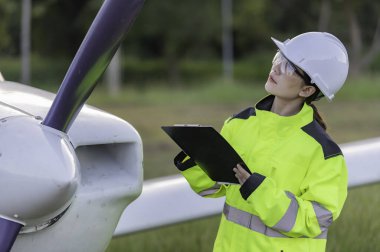 Teknisyen uçağın motorunu tamir ediyor. Kadın uzay mühendisliği uçak motorlarını kontrol ediyor. Asyalı tamirci uçak motorunu inceliyor