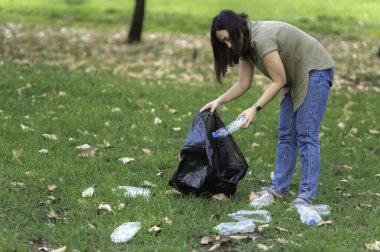 Asyalı anne ve kız, çöplerin toplanmasına yardım ediyor.