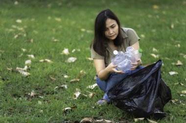 Asyalı anne ve kız, çöplerin toplanmasına yardım ediyor.