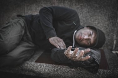 Asyalı adam yan yolda evsiz. Bir yabancı, ailesi olmadığı için yolda tek başına yaşamak zorundadır..