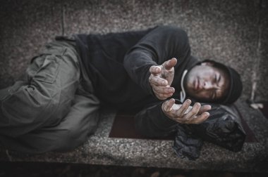 Asyalı adam yan yolda evsiz. Bir yabancı, ailesi olmadığı için yolda tek başına yaşamak zorundadır..