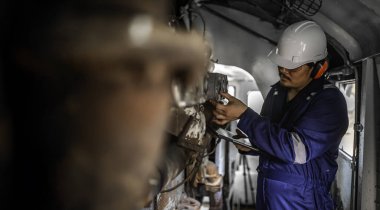 Makine mühendisi fabrikadaki büyük makineleri inceliyor. Demiryolu motor bakım teknisyeni, motor tamircisi.