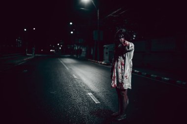 Korkunç kadın konsepti. Şehirdeki yolda bir hayalet var. Şehrin sokaklarında intikamcı bir ruh. Cadılar Bayramı festivali. Makyaj yapan hayalet surat