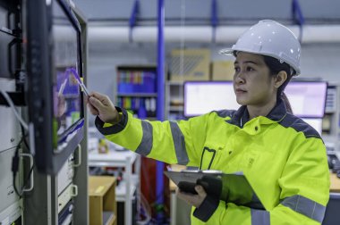 Elektrik mühendisi kadın kontrol odasındaki elektrik dağıtım kabinesindeki voltajı kontrol ediyor. Yıllık önleyici bakım. Tayland Elektrikçisi şirkette çalışıyor.
