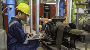 Isıtma tesisinde bakım teknisyeni. Petrokimya işçisi fabrikadaki gaz ve petrol boru hatlarının işletilmesini denetliyor. Mühendis işitme koruyucuyu birçok boruyla aynı odaya koydu.
