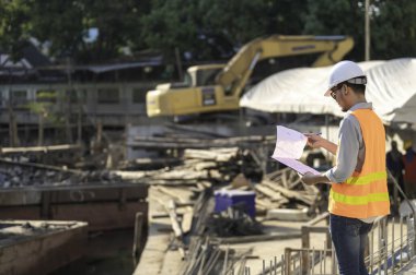 İnşaat mühendisi nehrin üzerinde köprü inşaatında çalışıyor. İnşaat mühendisi denetleme işi. Foreman bir inşaat alanında çalışıyor.