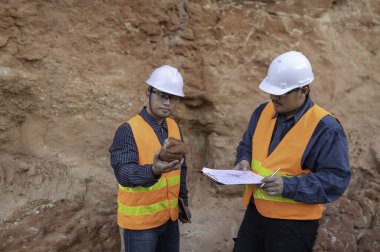 Jeologlar benimkini inceliyor. Kaşifler mineralleri aramak için toprak örnekleri topluyor..