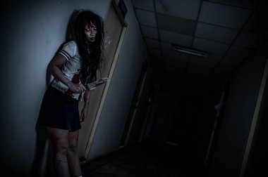 Hayaletten yapılmış Asyalı kadın portresi. Arka plan için korkunç bir korku sahnesi. Cadılar Bayramı festivali kavramı. Hayalet filmleri afişi, evde öfkeli bir ruh.