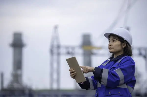 Asian woman petrochemical engineer working at oil and gas refinery plant industry factory. The worker woman engineer work control at power plant energy industry manufacturing