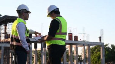 Büyük bir inşaat projesinde çalışan iki Asyalı mühendis. Taylandlılar. İnşaat alanında fazla mesai yapıyorum. Mimarlar ekibi olay yerinde diske girdi.
