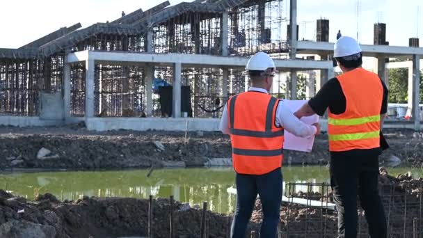 Zwei Asiatische Ingenieure Arbeiten Auf Der Baustelle Eines Großen Bauprojekts — Stockvideo