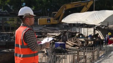 İnşaat mühendisi nehrin üzerinde köprü inşaatında çalışıyor. İnşaat mühendisi denetleme işi. Foreman bir inşaat alanında çalışıyor.