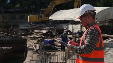 İnşaat mühendisi nehrin üzerinde köprü inşaatında çalışıyor. İnşaat mühendisi denetleme işi. Foreman bir inşaat alanında çalışıyor.