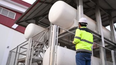 Isıtma sistemi ekipmanlarının yanındaki kazan bölgesinde çalışan Asyalı mühendis.