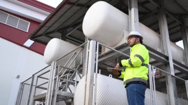 Isıtma sistemi ekipmanlarının yanındaki kazan bölgesinde çalışan Asyalı mühendis.