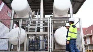 Isıtma sistemi ekipmanlarının yanındaki kazan bölgesinde çalışan Asyalı mühendisler, Taylandlılar. 