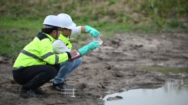 Çevre mühendisleri su kaynaklarındaki kirleticileri kontrol etmek ve su testinin sonuçlarını tekrar kullanmak için su kaynaklarında çalışırlar. Dünya çevre günü kavramı. 