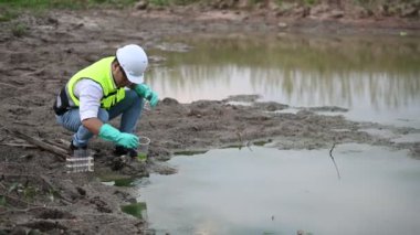 Çevre mühendisi su kaynaklarındaki kirleticileri kontrol etmek ve su test sonuçlarını tekrar kullanmak için analiz etmek için su kaynaklarında çalışıyor. Dünya çevre günü kavramı. 