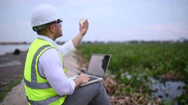 Çevre mühendisi su kaynaklarındaki kirleticileri kontrol etmek ve su test sonuçlarını tekrar kullanmak için analiz etmek için su kaynaklarında çalışıyor. Dünya çevre günü kavramı. 