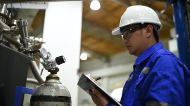 Endüstriyel fabrikada çalışan erkek mühendis panoya not alırken