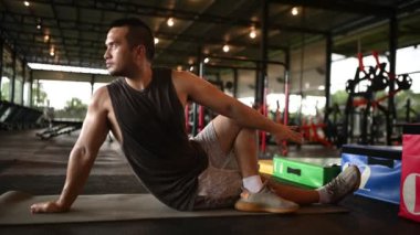 Genç yakışıklı adam spor salonunda antrenman yapıyor.