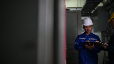 Elektrik mühendisleri endüstriyel kontrol odalarındaki elektrik sistemi arızalarını çözmek için birlikte çalışıyorlar..