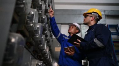 Elektrik mühendisleri endüstriyel kontrol odalarındaki elektrik sistemi arızalarını çözmek için birlikte çalışıyorlar..