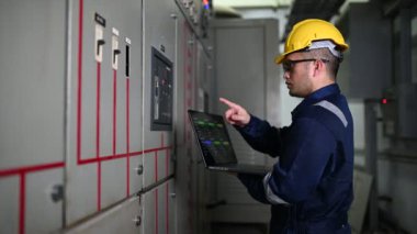 Güvenlik kaskı mühendisi ve fabrikadaki kontrol sistemi.