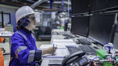 Tayland 'da, ameliyathanede çalışan Asyalı mühendis kask takıyor, özenle ve sabırla çalışıyor, hidrojen tankının valf düzenleyicisini kontrol ediyor..