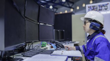 Tayland 'da, ameliyathanede çalışan Asyalı mühendis kask takıyor, özenle ve sabırla çalışıyor, hidrojen tankının valf düzenleyicisini kontrol ediyor..