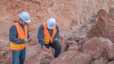 Benimkini araştıran bir jeolog, madenciler mineralleri aramak için toprak örnekleri topluyor..
