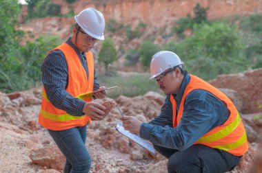 Benimkini araştıran bir jeolog, madenciler mineralleri aramak için toprak örnekleri topluyor..