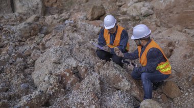 Benimkini araştıran bir jeolog, madenciler mineralleri aramak için toprak örnekleri topluyor..