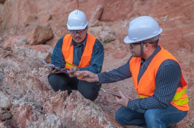 Benimkini araştıran bir jeolog, madenciler mineralleri aramak için toprak örnekleri topluyor..