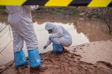 Su analizinde birlikte çalışan bilim adamları ya da biyologlar koruyucu üniformalar giyiyorlar. Çevre mühendisleri tehlikeli bir bölgedeki su kalitesini inceliyorlar.