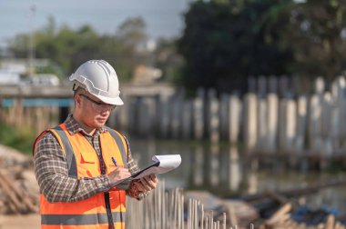 Köprü inşaatında çalışan inşaat mühendisi inşaat mühendisi, inşaat mühendisi denetleme işi, Foreman inşaat sahasındaki işi denetliyor.
