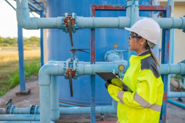 Çevre mühendisleri atık su arıtma tesislerinde çalışıyor. Su ikmali yapan kadın tesisatçı teknisyen.